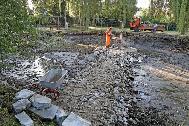 Bauhofmitarbeiter Siegfried Gebhardt bei Stemmarbeiten am Betonsockel der alten Wasserfontäne im ausgepumpten Teich im Bernhard-Bauer-Park in Wickede. FOTO: ANDREAS DUNKER 