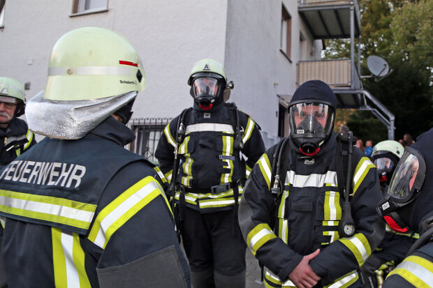 Feuerwehrleute mit schwerem Atemschutz vor dem Wohnhaus FOTO: ANDREAS DUNKER