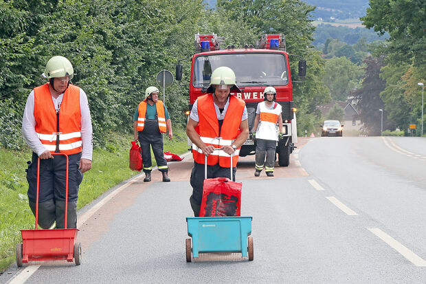 Über mehrere Kilometer brachten Feuerwehrleute das Bindemittel auf die ölverschmierte Fahrbahn der Hauptstraße in Wickede auf. FOTO: ANDREAS DUNKER