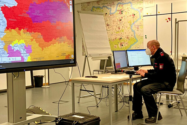 Ein Mitarbeiter der Feuerwehr beobachten in der Rettungsleitstelle in Soest die Warnungen vor Unwetter auf einer metereologischen Karte auf einem großen Bildschirm im Rettungszentrum in Soest, um die Einsatzkräfte in der Region zu koordinieren. FOTO: FEUERWEHR KREIS SOEST