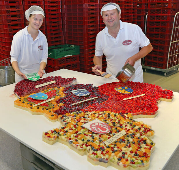 Konditormeister Roman Palczewski (rechts) und Gesellin Maike Lichterfeld (links) bei der Produktion des individuellen Geburtstagskuchens mit den Grenzen der Gemeinde und der Ortsteile FOTO: ANDREAS DUNKER
