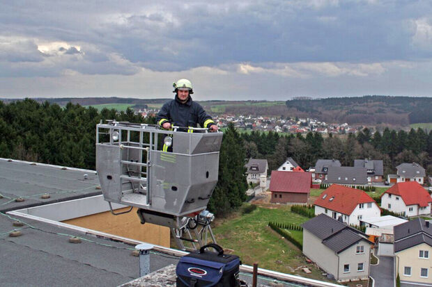 Feuerwehrmann Thomas Hauschulte schwebt im Korb der dreißig Meter langen Drehleiter über dem Dach des vermeintlichen "Hochhauses" im Hövel FOTO: BILDSAMMLUNG THOMAS HAUSCHULTE