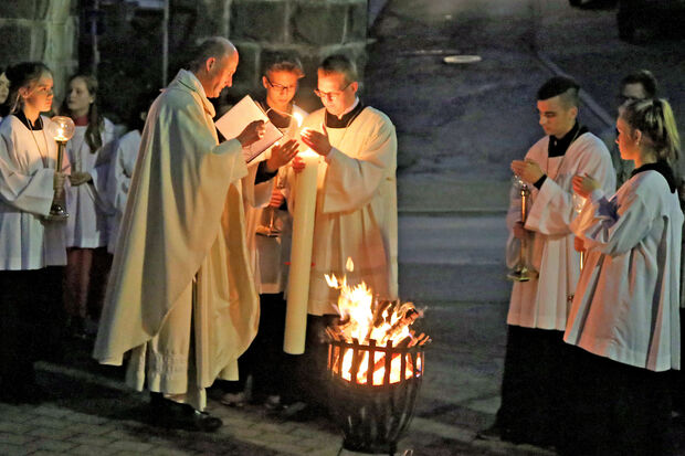 Pfarrer Thomas Metten entzündete am Karsamstag vor der katholischen St.-Antonius-Kirche die neue Osterkerze. FOTO: ANDREAS DUNKER
