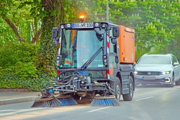 Die Kehrmaschine des kommunalen Bauhofes fegte das Bindemittel anschließend wieder zusammen und saugte es auf. Dabei entstand stellenweise eine erhebliche Staubwolke. FOTO: ANDREAS DUNKER