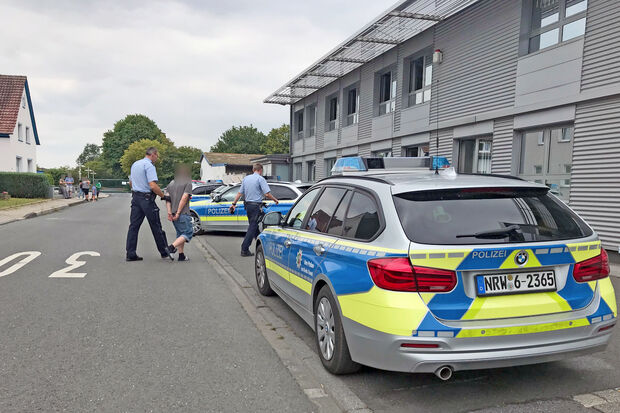 Zwei Polizei-Beamte führen den mutmaßlichen Straftäter in Handschellen ab und nehmen ihn in Gewahrsam. FOTO: ANDREAS DUNKER
