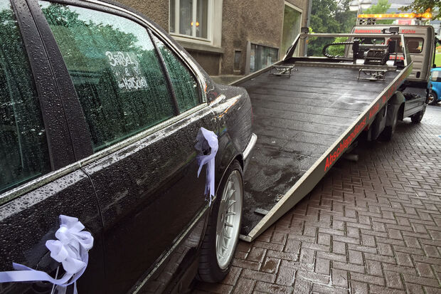 Scharzes Auto mit weißen Schleifchen: die Hochzeitslimousine und der Abschleppwagen FOTO: ANDREAS DUNKER