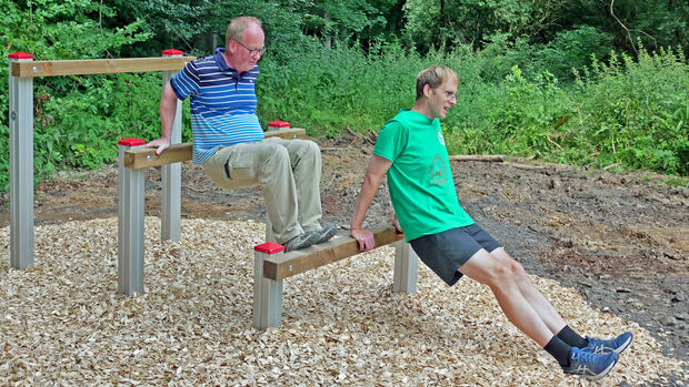 Der „Trimm-Dich-Pfad“ lädt mit Informationstafeln zu sportlichen Übungen aus den Bereichen „Ausdauer und Koordination“, „Kraft“ sowie „Dehnung und Entspannung“ ein. Hier die Werler Ratsherren Hubertus Wulf und Frank Potthoff (von links) beim Training. FOTO: TOBIAS GEBHARDT
