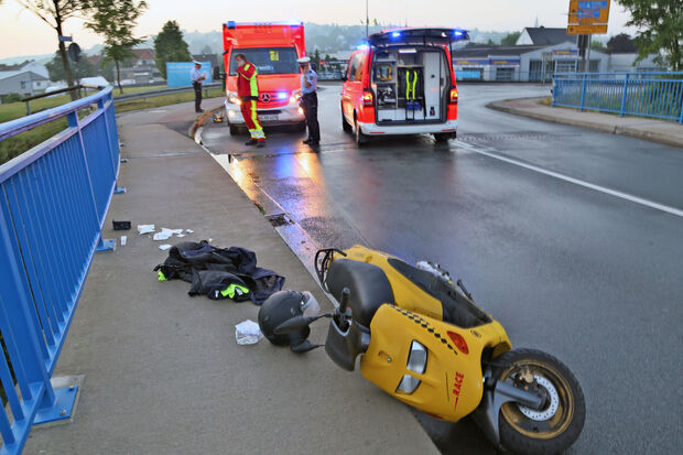 Der gestürzte Motorroller auf der Ruhrbrücke. Im Hintergrund: Polizei und Rettungsdienst. FOTO: ANDREAS DUNKER