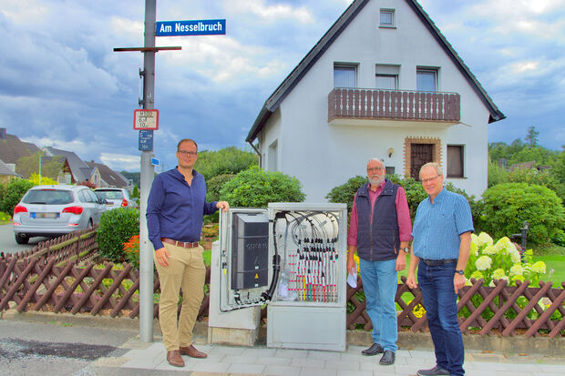 Johannes Kobeloer als zuständiger Kommunalbetreuer der Westenergie AG, Bürgermeister Dr. Martin Michalzik (CDU) von der Gemeinde Wickede (Ruhr) und Wimberns Ortsvorsteher Edmung Schmidt vor einem geöffneten Schaltkasten an der Straße "Am Nesselbruch" in Wimbern. FOTO: ANDREAS DUNKER