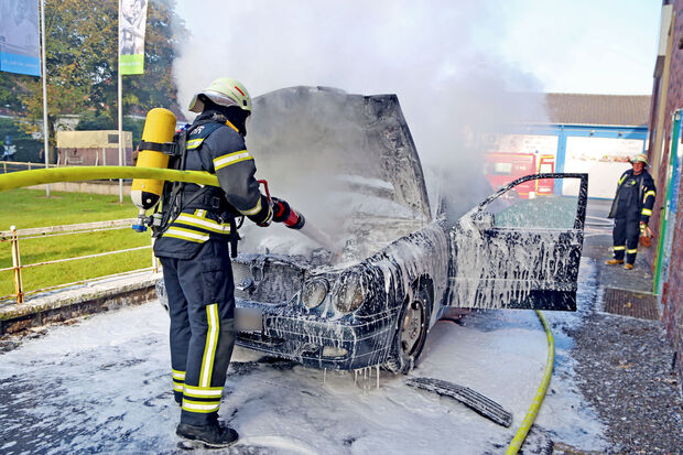 Ein Feuerwehr-Mann löscht den brennenden Motorraum des Pkw. FOTO: ANDREAS DUNKER